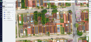 Imagem aérea de área urbana exibida em sistema de mapa digital do CTM, com lotes e edificações destacados por cores e limites demarcados. A tela mostra camadas de cadastro técnico multifinalitário com informações territoriais organizadas para gestão municipal.