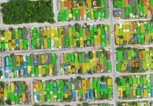 Mapa aéreo urbano com imóveis destacados em cores, representando análise cadastral para gestão tributária municipal.